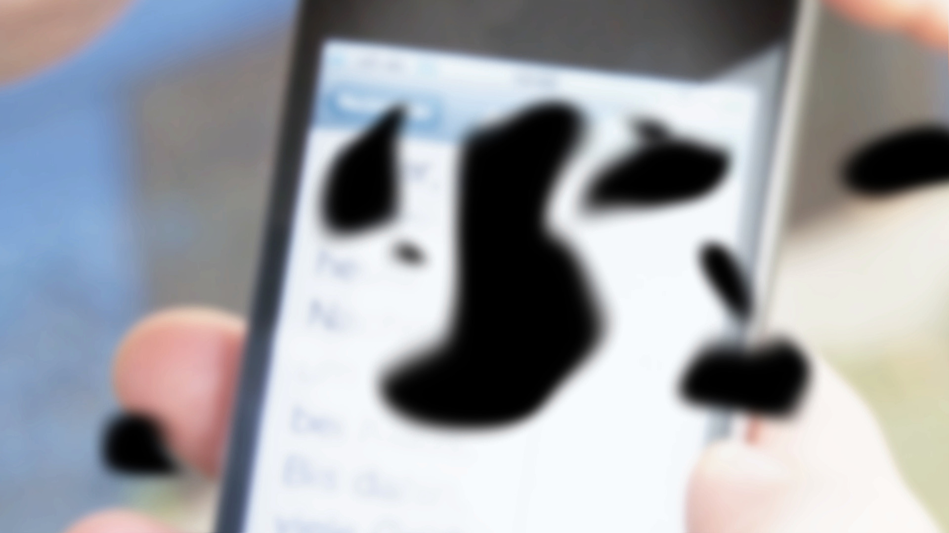 Blick auf einen Smartphone-Bildschirm, unscharf und mit schwarzen Flecken.