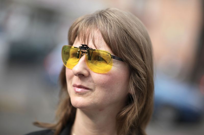 Eine Frau trägt einen Brillenaufsatz mit gelb getönten Gläsern über ihrer Brille.